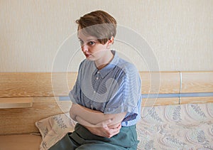 Depressed young woman sits in the bedroom, unhappy female suffering from insomnia or depression, psychological problem