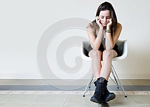 Depressed young woman sitting at home.