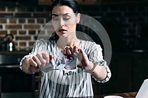 depressed young woman tearing photo of ex-boyfriend