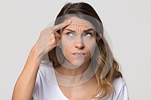 Depressed young woman touching forehead worried about skin wrinkle photo
