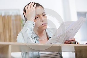 depressed young woman trying to assemble furniture