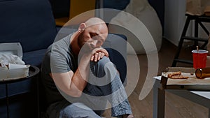 Depressing unhappy hopeless worried man sitting on floor feeling loneliness