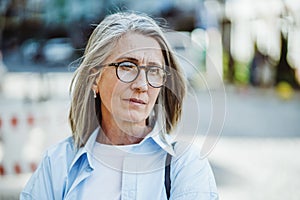 Depression that can be in old age Unhappy mature lady, standing across street, lost in thoughts Emotional challenges