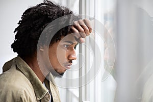 Depression Concept. Portrait Of Pensive Upset Young Black Man Looking Out Window