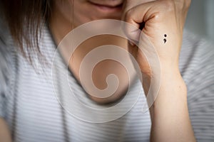 Depression concept - semicolon tattoo as symbol of mental illness