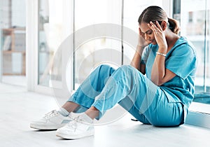 Depression, headache and medical with nurse on floor of hospital for sad, mental health and burnout. Anxiety, stress and