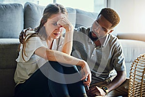 Depression, sad and compassion with a man and woman comforting or consoling in a home living room. Couple, love and