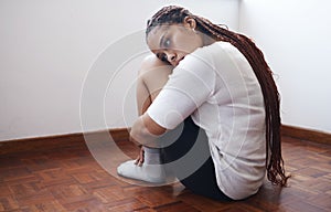 Depression, stress and anxiety with a woman suffering with her mental health while sitting on the floor alone. Sad, fear