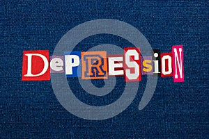 DEPRESSION word text collage, multi colored fabric on blue denim, mental health concept