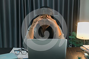 Depression at work. Asian Businesswoman sitting and working hard at with front of computer and lots of documents on table in