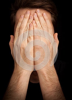 Depression â€“ man covering face with hands