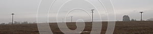 Depressive, ghostlike and foggy winters day in Czech countryside. Meadow with electric posts in the fog photo