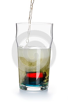 Depth charge cocktail of beer, blue Curacao liqueur, grenadine and vodka, prepared by mixing a submerged inverted Cup at