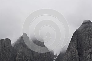 Black and white sharp peaks of mountaintop with fog photo