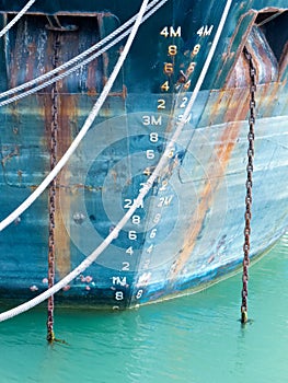 Depth scale on bow of anchored ship in grungy blue