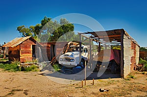 Derelict abandoned farm buildings and an old truck in the desert of South Australia