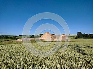 Derelict abandoned farmhouse on top of hill in English field