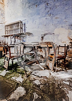 Derelict building with broken chairs scattered around