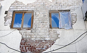 Derelict building with two windows and broken plaster