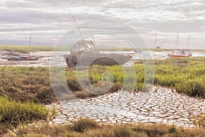 Derelict fishing boats on misty riverbanks