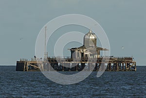 A derelict pier lying abandoned off the Kent coast of Herne bay England. It is being used by seabirds as a safe place to roost.