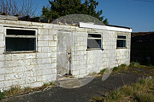 Derelict single story white building