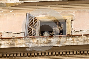 Derelict window and balcony on old builiding in Psirri neighborhood, Athens