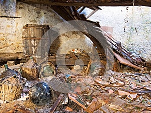 Dereliction, tumbledown abandoned property, cellar with demijohns. photo