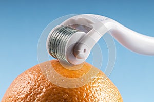 Derma roller for medical micro needling therapy with orange.