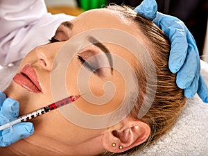 Dermal fillers of woman in spa salon with beautician.