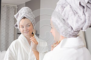 Dermaroller. Woman is making procedure on face with meso roller in home