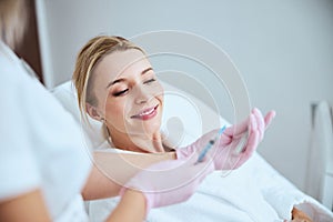 Dermatologist demonstrating the medical tools to a female patient