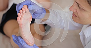 A dermatologist examines a foot with red vesicles