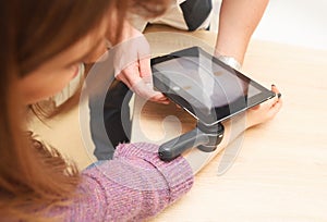 dermatologist examines moles on a female patient& x27;s arm with a dermatoscope and a computer tablet. Prevention of