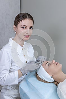 A dermatologist examines the skin on the patient& x27;s face