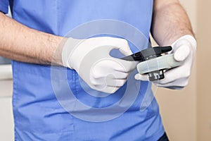 Dermatologist examines test cancer device mole hand control checking scan checkout phone