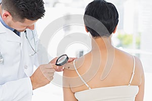 Dermatologist examining melanoma on woman