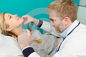 Dermatologist examining mole with magnifying glass in clinic