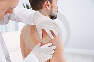 Dermatologist examining patient`s birthmark