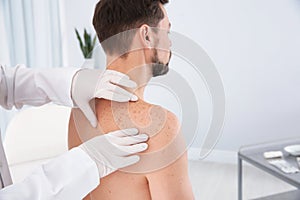 Dermatologist examining patient`s birthmark