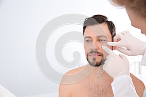 Dermatologist examining patient`s birthmark in clinic.