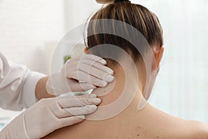 Dermatologist examining patient`s birthmark in clinic