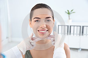 Dermatologist examining patient`s face in clinic.