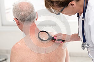 Dermatologist examining the skin of a patient