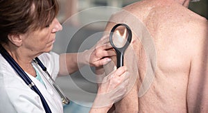 Dermatologist examining the skin of a patient