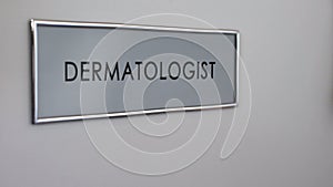 Dermatologist room door, patient hand knocking closeup, skin examination, health