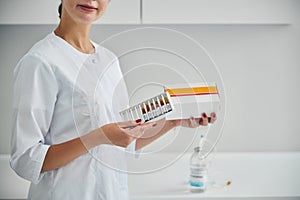 Dermatologist showing a set of sealed ampules