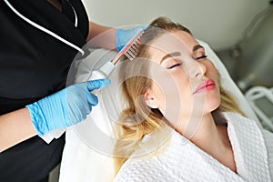 dermatologist trichologist performs the procedure with a darsonval device to improve the condition and quality of