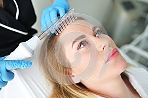 dermatologist trichologist performs the procedure with a darsonval device to improve the condition and quality of