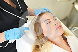 dermatologist trichologist performs the procedure with a darsonval device to improve the condition and quality of